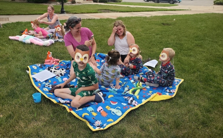 children reading on blanket outside