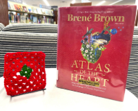 red and green crocheted granny square next to a red book title Atlas of the Heart by Brene Brown