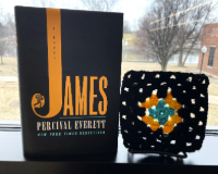 The book James by Percival Everitt next to a black and yellow crocheted granny square