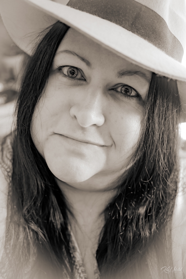 woman with dark hair wearing a hat