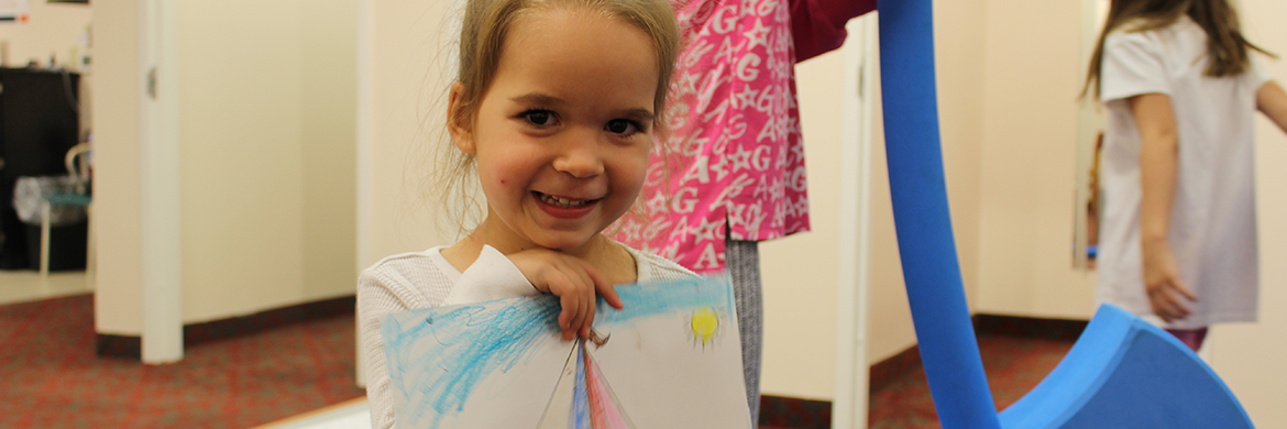 Young girl holds up her drawing at the HPL Express Launch